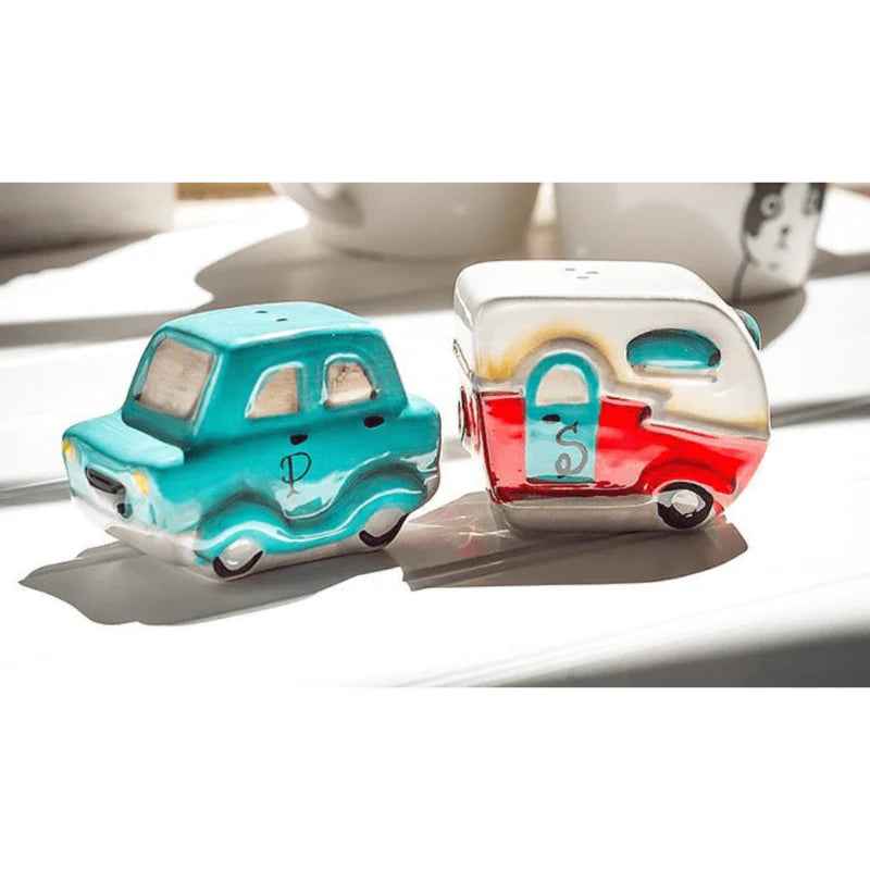 Salt and pepper shakers shaped like a turquoise car and red camper on a white surface.