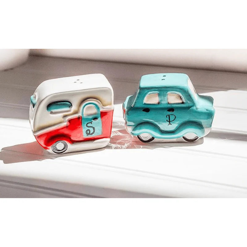 Two colourful car and camper salt and pepper shakers on a white surface