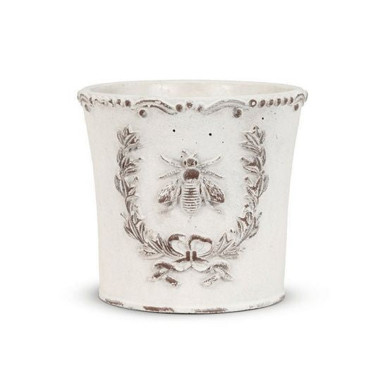 Decorative white planter with bee design on a white background