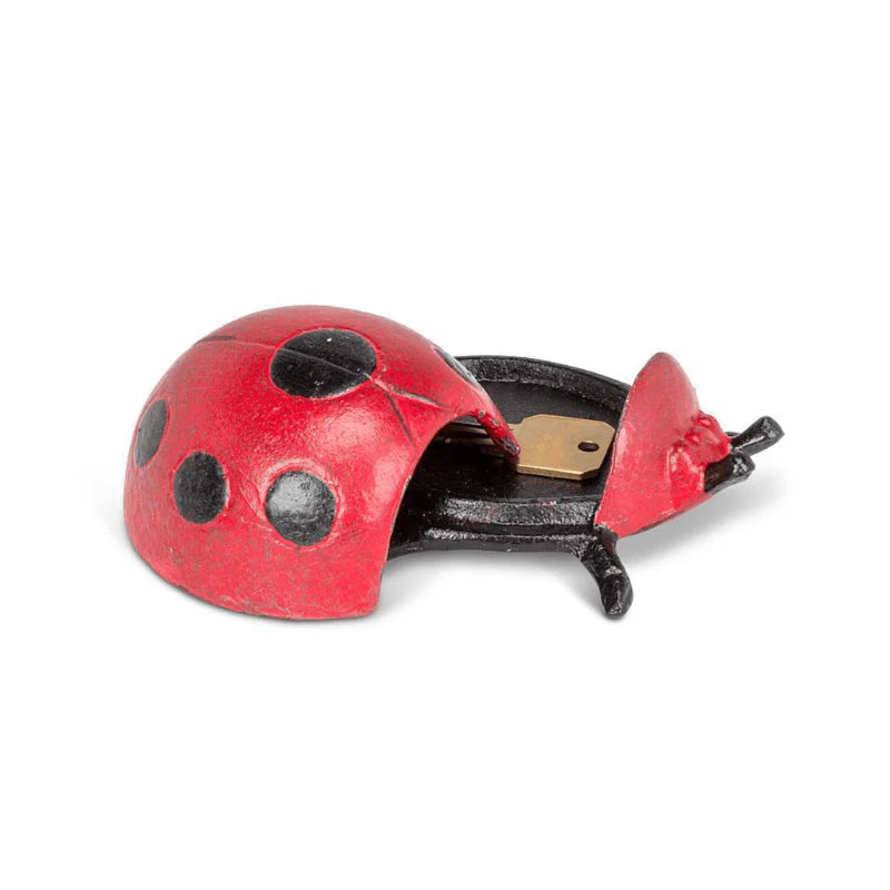 Red ladybug-shaped key keeper with a key inside on a white background