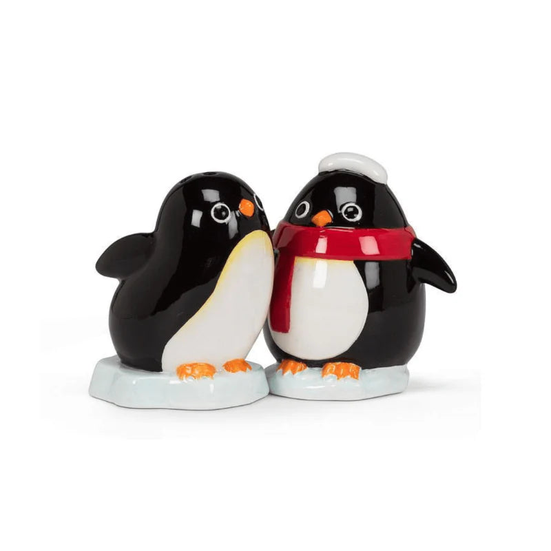 Winter penguin salt and pepper shakers, one with a red scarf and hat, on a white background