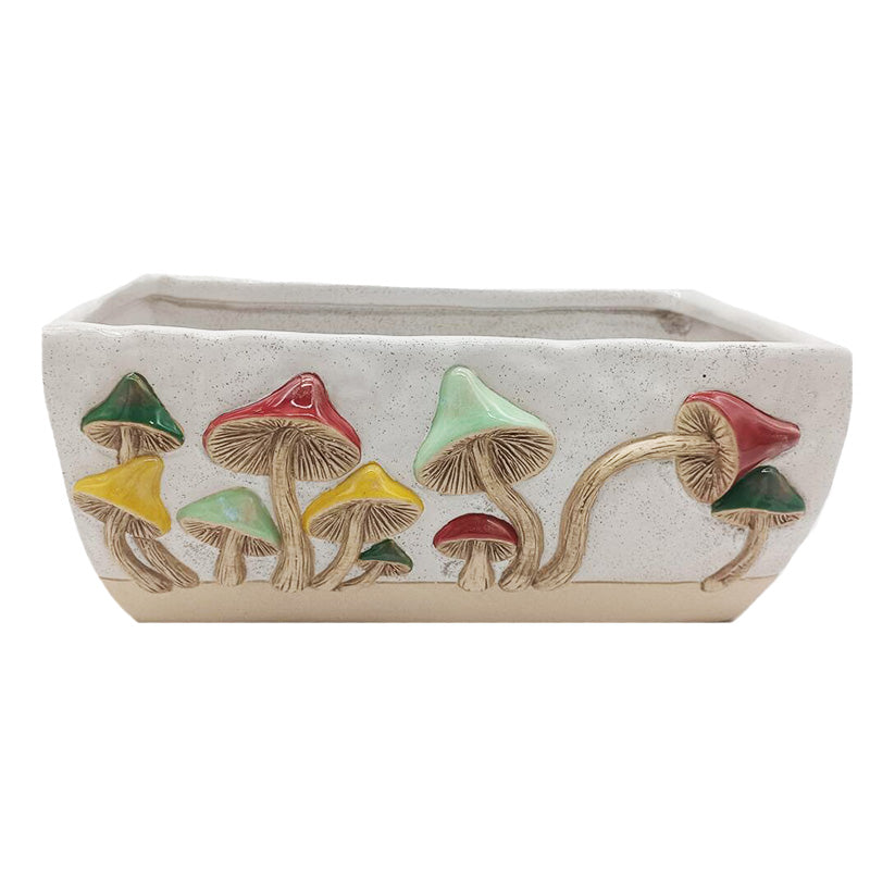 A rectangular ceramic planter with a speckled off-white glaze, featuring a raised relief design of various colorful mushrooms in green, red, yellow, and light blue on the front.