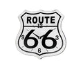 Route 66 sign on a brick wall with a red vehicle and fan in the foreground.