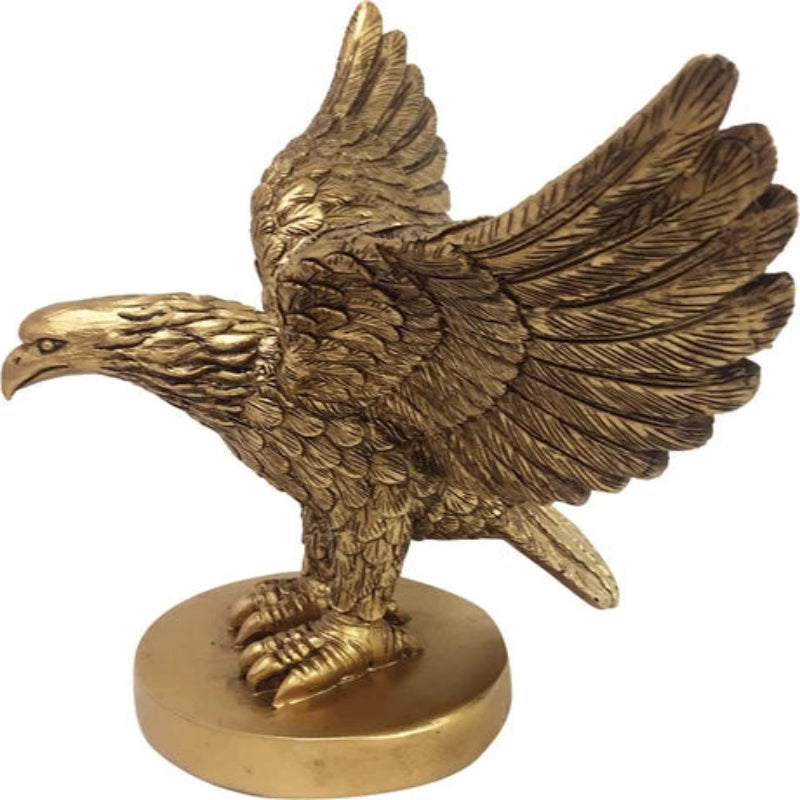 A metallic gold eagle figurine with wings spread, standing on a round pedestal base against a plain white background.